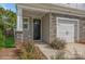 Front entry of townhome with stone accents and a black front door at 33 Woodsdale Se Pl, Concord, NC 28025