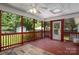Red painted back porch with screened sides, overhead fan, and an open view into the spacious backyard at 3531 Enfield Rd, Charlotte, NC 28205
