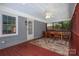 Enclosed back porch with painted brick, ceiling fan, and painted floors with a geometric design area rug at 3531 Enfield Rd, Charlotte, NC 28205