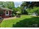 Expansive backyard with a seating area, a grill, green grass, various trees and landscaping, and a shed at 3531 Enfield Rd, Charlotte, NC 28205