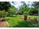 Green backyard featuring manicured landscaping, garden beds, mature trees, and an outdoor seating area at 3531 Enfield Rd, Charlotte, NC 28205