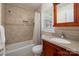 Cozy bathroom with shower-tub combo, wood cabinet, and decorative tile accents at 3531 Enfield Rd, Charlotte, NC 28205