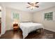 Bright bedroom featuring hardwood floors, a ceiling fan, and natural light from two windows at 3531 Enfield Rd, Charlotte, NC 28205