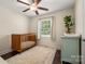 Bedroom featuring hardwood floors, natural light, a crib, and changing table at 3531 Enfield Rd, Charlotte, NC 28205