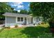 Charming single-story home featuring a well-manicured lawn, painted brick, and a welcoming front porch at 3531 Enfield Rd, Charlotte, NC 28205