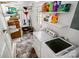Bright laundry area with washer, dryer, storage shelves, and utility sink at 3531 Enfield Rd, Charlotte, NC 28205