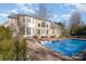 Back of brick home featuring a large pool, and fenced yard under a bright blue sky at 4316 Mourning Dove Dr, Matthews, NC 28104