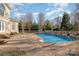 Backyard featuring a large pool, deck area, and a white fence against a backdrop of mature trees at 4316 Mourning Dove Dr, Matthews, NC 28104