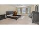 Bedroom featuring neutral carpeting, several windows, a dark bedframe, and an accent chair at 4316 Mourning Dove Dr, Matthews, NC 28104