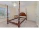 Bedroom features a wooden four-poster bedframe, neutral carpeting, and natural light from a window at 4316 Mourning Dove Dr, Matthews, NC 28104