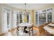 Sun-filled breakfast nook with a modern table, chandelier, and views of the outdoor pool at 4316 Mourning Dove Dr, Matthews, NC 28104