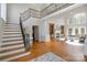 Elegant foyer with hardwood floors, grand staircase with iron railing, and view into the living area at 4316 Mourning Dove Dr, Matthews, NC 28104