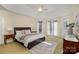 Bright main bedroom with a tray ceiling, large windows, and neutral decor at 4316 Mourning Dove Dr, Matthews, NC 28104