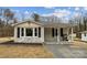 Charming one-story home featuring gray brick, black shutters, and a covered porch with a grill at 5483 Paulmo Dr, Charlotte, NC 28216