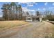 White single-story home with a gravel driveway and manicured landscaping at 5483 Paulmo Dr, Charlotte, NC 28216