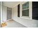 Inviting front porch with a gray door, sidelight, and a 'Wipe Your Paws' doormat at 5483 Paulmo Dr, Charlotte, NC 28216