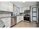 Modern kitchen featuring stainless steel appliances, white cabinets, granite countertops, and backsplash at 5483 Paulmo Dr, Charlotte, NC 28216