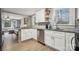 Open kitchen with white cabinets, stainless steel appliances, and a view into the living room at 5483 Paulmo Dr, Charlotte, NC 28216