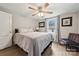 Comfortable main bedroom with light wood floors, complemented by a ceiling fan, a chair, and a window view at 5483 Paulmo Dr, Charlotte, NC 28216