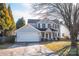 Two-story house with gray siding, attached garage, and a well-maintained lawn at 5711 Falls Ridge Ln, Charlotte, NC 28269