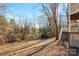 Sloped backyard with mature trees and partial view of a wooden fence at 6017 Millbury Ct # 16, Charlotte, NC 28211