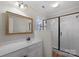 Bathroom with white vanity, large mirror, and glass shower enclosure at 6017 Millbury Ct # 16, Charlotte, NC 28211