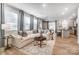 Sunlit living room featuring a plush sectional sofa, stylish decor, and an open layout connected to the kitchen at 624 Cassidy Ct, Clover, SC 29710