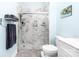 Bathroom with a walk-in shower, marble tile, and storage shelves with towels and bath products at 780 N Davidson St, Charlotte, NC 28202