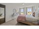 This bedroom is bright and airy with a large window, neutral decor, and a decorative mirror at 820 Regulus Ct, York, SC 29745