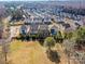 Aerial view of a residential neighborhood with houses, lawns and roadways in a wooded setting on a sunny day at 9730 Briarwick Ln, Charlotte, NC 28277