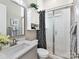 Bright bathroom featuring a shower with glass door, white cabinets, gray vanity and decorative shower curtain at 9730 Briarwick Ln, Charlotte, NC 28277