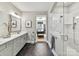 Luxurious bathroom featuring dual vanities, black tile floors, and a walk-in glass shower at 9730 Briarwick Ln, Charlotte, NC 28277