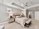 Bedroom featuring a tray ceiling, ceiling fan, and view of a bed with an upholstered headboard at 9730 Briarwick Ln, Charlotte, NC 28277