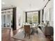 Elegant dining area with a marble table, seating for six, modern chandelier, and natural light from large windows at 9730 Briarwick Ln, Charlotte, NC 28277