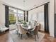 Bright dining room featuring a modern chandelier, large windows, and a stylish marble table with seating for six at 9730 Briarwick Ln, Charlotte, NC 28277