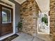 Inviting front porch with stone accents, a cozy seating area with white rocking chairs, and a wooden front door at 9730 Briarwick Ln, Charlotte, NC 28277