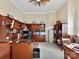 Well-lit home office with custom wood shelving, desk, and cozy reading nook at 9730 Briarwick Ln, Charlotte, NC 28277