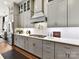 Modern kitchen featuring gray cabinetry, stainless steel appliances, a quartz countertop, and decorative backsplash at 9730 Briarwick Ln, Charlotte, NC 28277