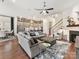 Open-concept living space with a comfortable gray sectional, modern kitchen, dining area, and fireplace at 9730 Briarwick Ln, Charlotte, NC 28277