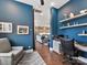 Stylish home office with blue walls, built-in shelves, and a view into the open-concept living area and kitchen at 9730 Briarwick Ln, Charlotte, NC 28277