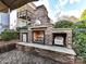 Brick outdoor fireplace featuring a hearth and wood storage, perfect for outdoor gatherings and relaxation at 9730 Briarwick Ln, Charlotte, NC 28277