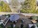 Aerial view of a cozy patio with a fireplace, dining set, and lush landscaping, creating a private outdoor retreat at 9730 Briarwick Ln, Charlotte, NC 28277