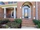 Inviting front entrance with brick steps, arched doorway, and a covered porch at 1016 Antioch Woods Ln # 36, Weddington, NC 28104