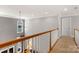 Hallway features hardwood railing, neutral paint, and natural light from a window over the stairwell at 1016 Antioch Woods Ln # 36, Weddington, NC 28104