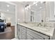 Well-lit bathroom with double sinks, and a doorway view into the bedroom at 11400 Five Cedars Rd, Charlotte, NC 28226