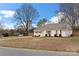 Charming single-story home with white painted brick, shuttered windows, mature trees, and manicured lawn at 11400 Five Cedars Rd, Charlotte, NC 28226