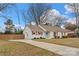 Charming single-story home with a well-manicured lawn, wooden shutters, and a blue front door at 11400 Five Cedars Rd, Charlotte, NC 28226