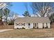 Inviting exterior of home with a bright blue door, wooden shutters, and tidy landscaping at 11400 Five Cedars Rd, Charlotte, NC 28226