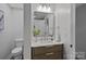 Vanity with wood grain accents, marble countertop, and modern fixtures at 1213 Hartford Ave, Charlotte, NC 28209