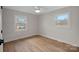 Well-lit bedroom with hardwood floors and two windows at 1213 Hartford Ave, Charlotte, NC 28209